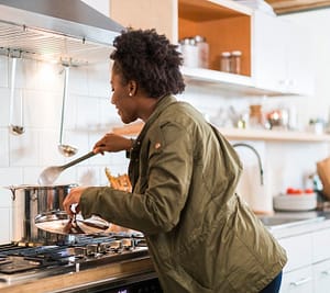 An afro-american girl cooking a soup